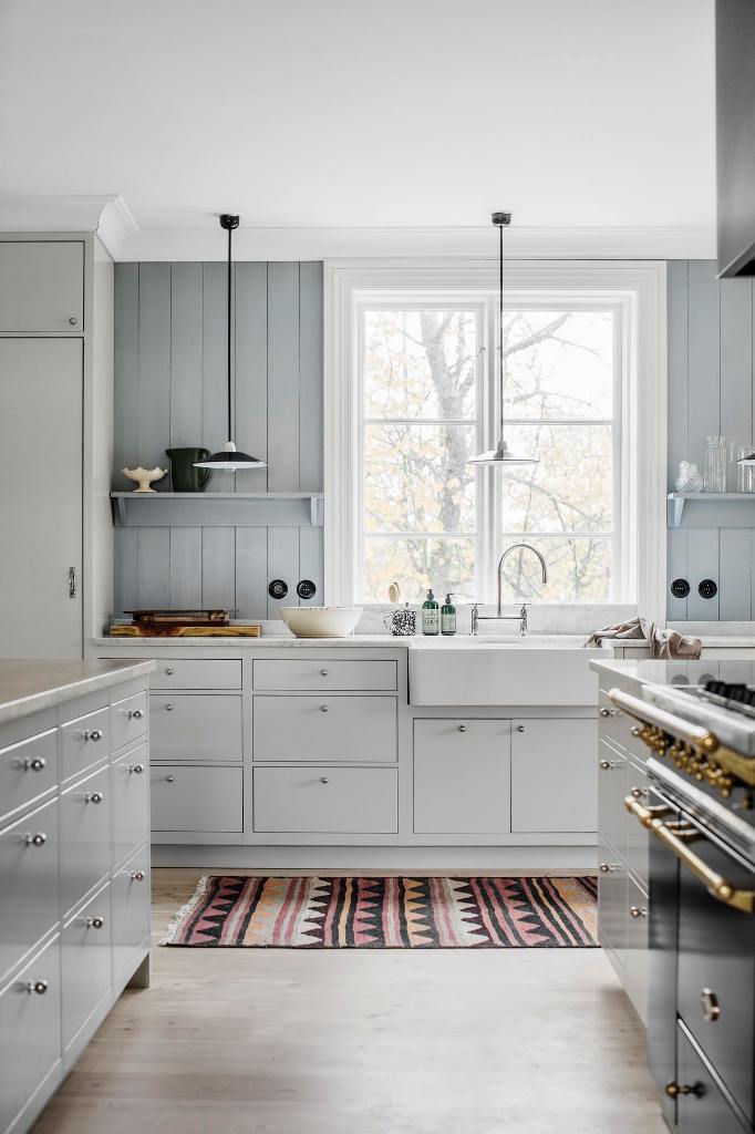 The kitchen is clad with grey wood and off white cabinets