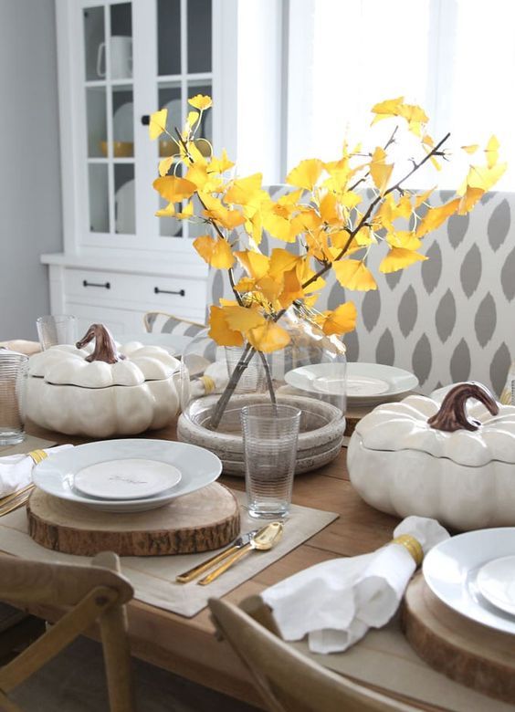 a cozy fall table setting with a fall leaf centerpiece, wood slice placemats and faux pumpkin salad bowls