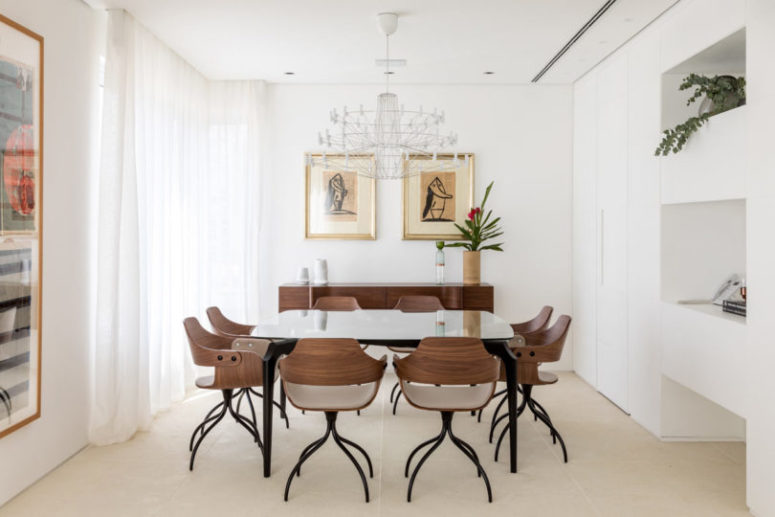 The dining room is done with quirky chairs, cool artworks and a chic chandelier for a statement