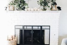 05 a fresh and natural feel given to the mantel with fresh greneery, white pumpkins and lanterns on each side