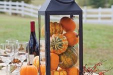 a lantern centerpiece is ideal for an outdoor dinner, fill it with pumpkins and gourds