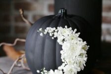 06 a matte black pumpkin decorated with white flowers as a moon is a beautiful Halloween decoration