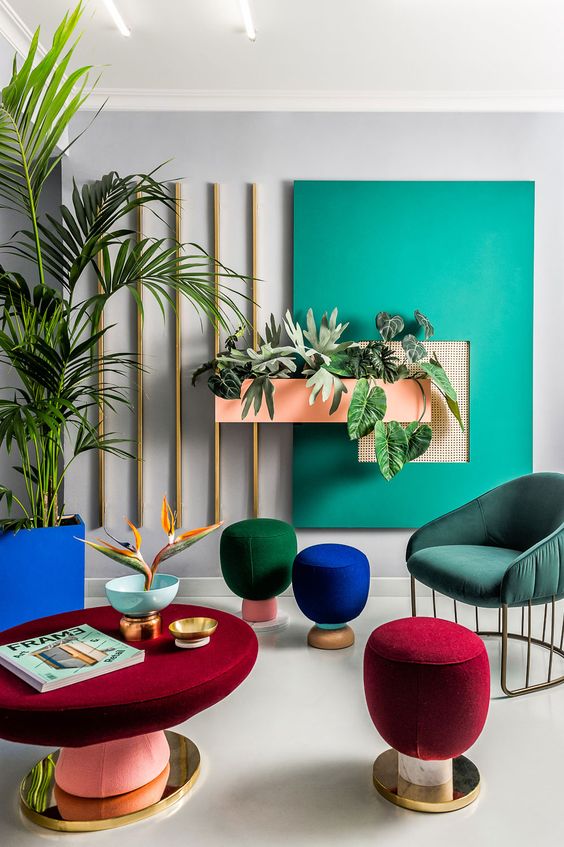 a super colorful space with jewel tone stools and colorful upholstered furniture plus a colorful accent wall