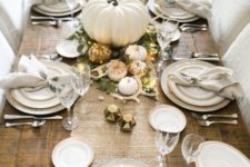 06 a table runner of white burlap, little white and gilded pumpkins, greenery, antlers and LEDs on an uncovered table