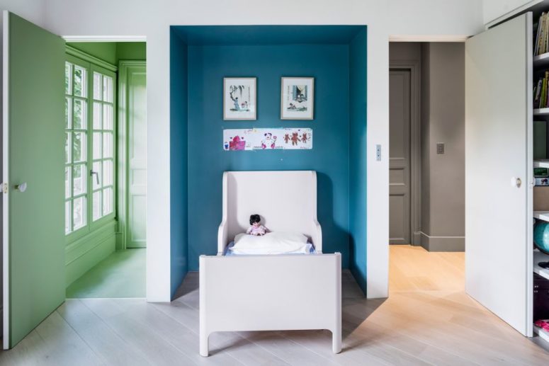 Another kid's bedroom is done with a blue niche, a comfy kid's bed and colorful doors add to the space