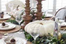 07 a neutral table setting with large white pumpkins and candles, pinecones, fresh greenery and woven placemats