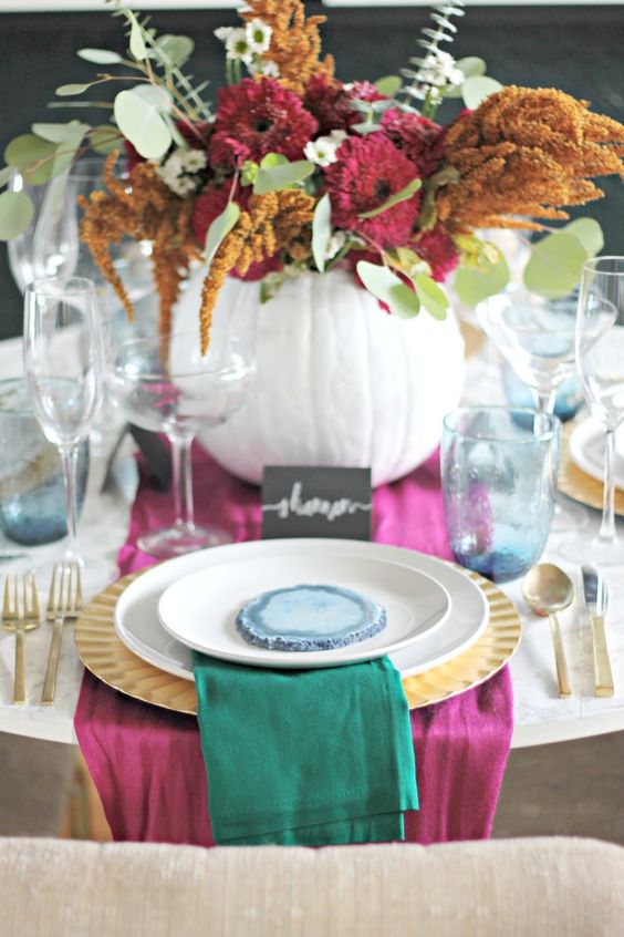 pink and emerald textiles and a bold floral centerpiece with pink and mustard blooms and greenery