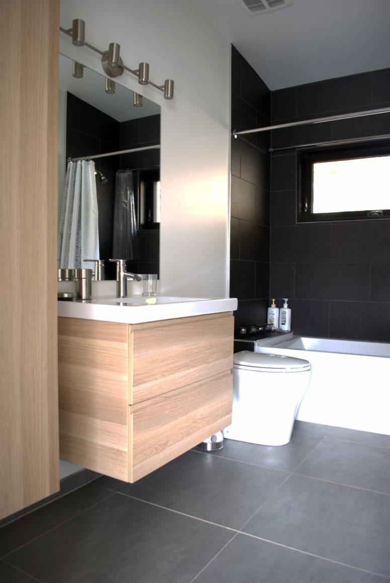 The bathroom is done in minimalist style, just like the rest of the house and features the same materials in decor