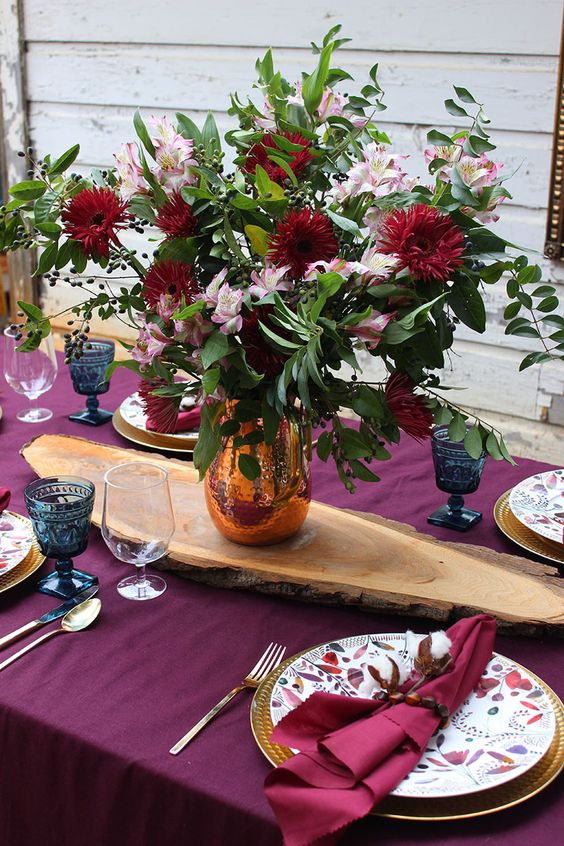 go for a fuchsia tablecloth and napkins, bright blooms and gilded cutlery for Thanksgiving and enjoy the color