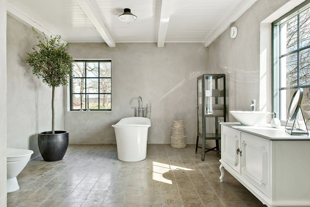 The bathroom is a large space with vintage furniture and a view plus a glass armoire