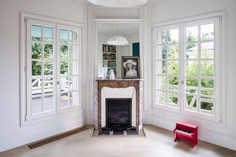 The living room shows off a vintage fireplace and French windows