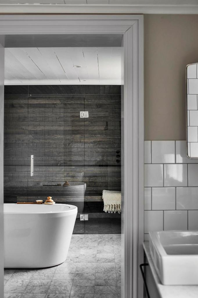 The second space is clad with weathered wood, there's a shower and a large bathtub