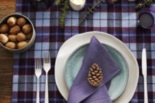 10 a plaid purple and burgundy tablecloth, a purple napkin, a blue plate and a purple glass pitcher look cozy