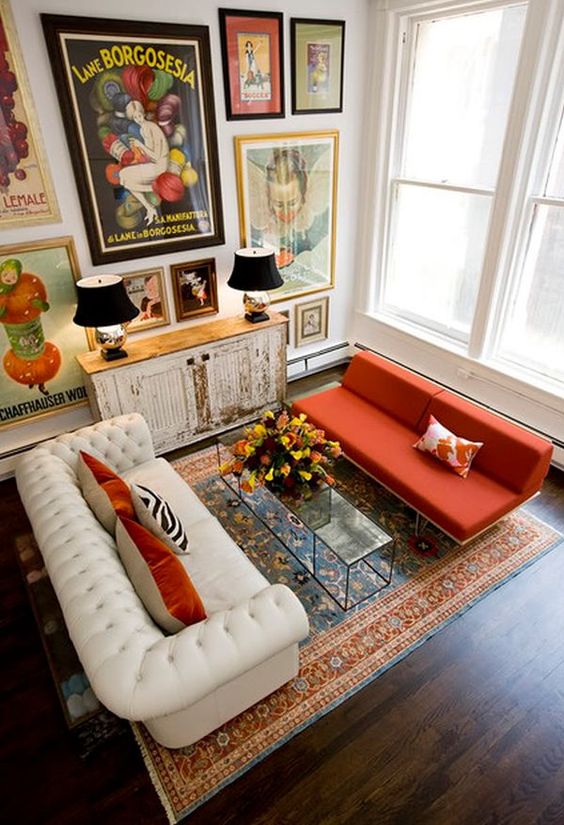an eclectic living room with a bright gallery wall with vintage posters and artworks