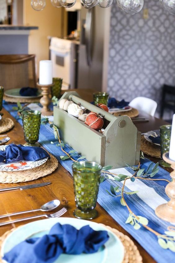 a simple and rustic Thanksgiving setting with a bold blu runner and napkins plus green glasses