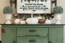 11 a vintage and rusty console with fabric pumpkins, faux greenery in pots and cool decor on the wall with a sign