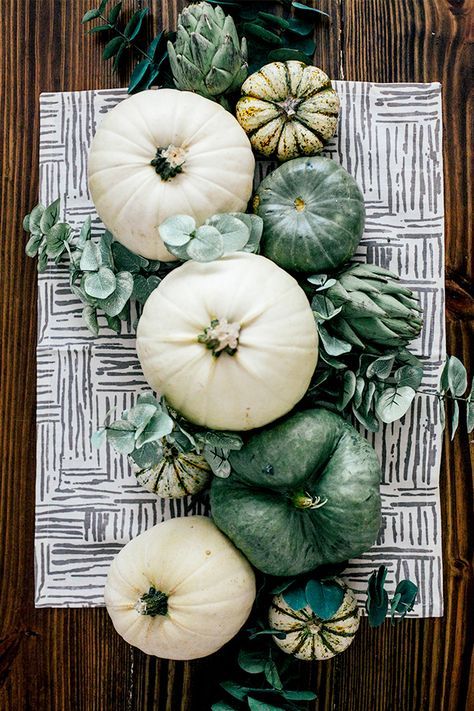 a cute natural Thanksgiving centerpiece of white and green heirloom pumpkins and fresh eucalyptus