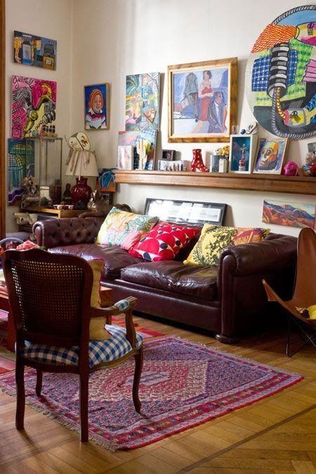 a traditional space spruced up with super bold and vibrant artworks and pillows and rugs that create a mood