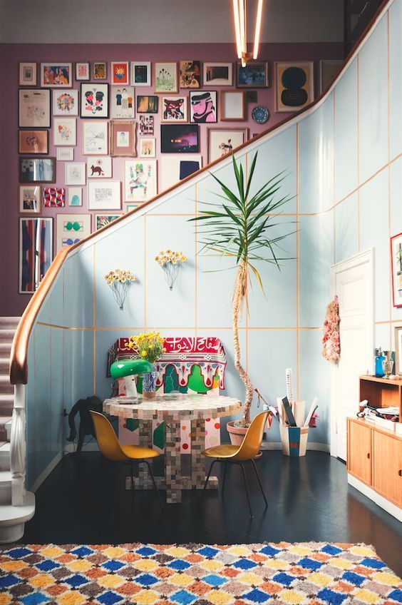 a colorful space and a pink wall that is completely covered with bright artworks for a bold touch