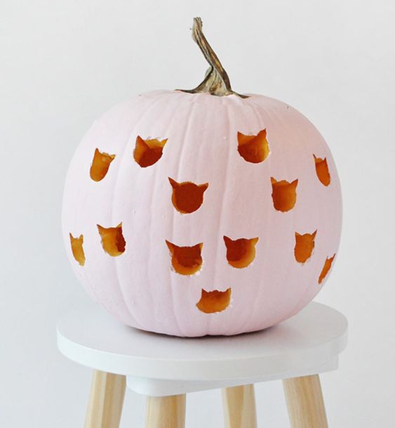 a pink carved pumpkin with cat heads for Halloween decor and a girlish touch