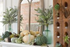 13 a rustic Thanksgiving mantel with various pumpkins, pinecones, greenery in bottles and leaves