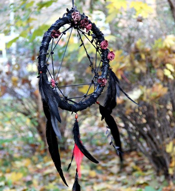 A black dream catcher with black feathers and fake roses looks very witchy and boho like