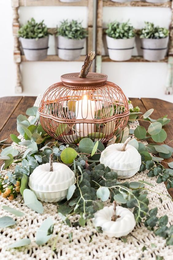 a chic Thanksgiving centerpiece with a macrame table runner, greenery, a candle in a copper candle holder