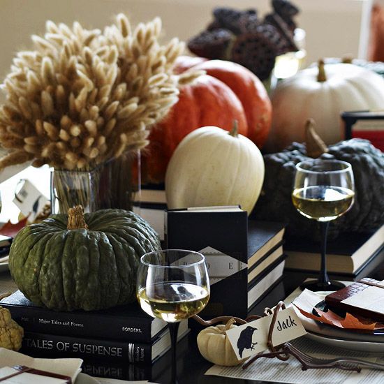 black books and various heirloom pumpkins plus a wheat arrangement in a vase for a chic Halloween centerpiece
