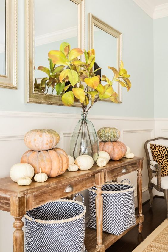 a cozy Thanksgiving console with fabric baskets, heirloom pumpkins and fall leaf branches in a vase