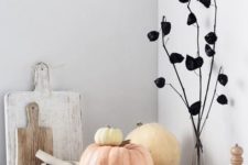 15 a modern Halloween arrangement with natural pumpkins and a plant dyed black for a modern feel