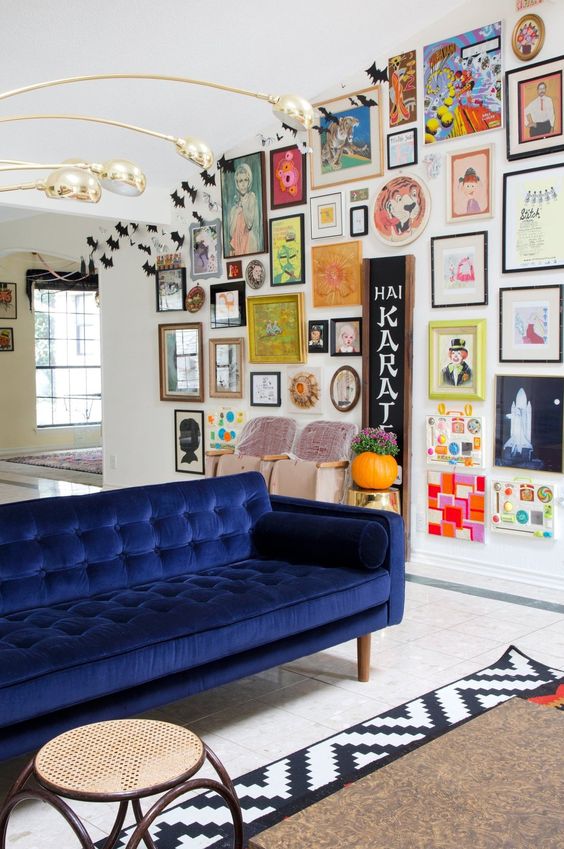 a colorful space with a bold gallery wall with various artworks and mirrors