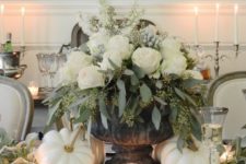 16 a luxurious Thanksgiving centerpiece with a vintage urn, seeded eucalyptus, white roses, berries and white pumpkins around