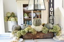16 a rustic Thanksgiving centerpiece of white and green pumpkins and green hydrangeas in an industrial crate