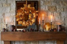 16 a rustic fall mantel with pinecones, candles, a fall leaf wreath for a cozy and comfy feel