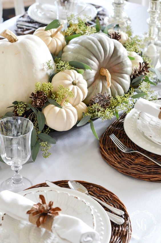 a natural fall centerpiece of a tray, seeded eucalyptus, heirloom pumpkins and pinecones for a rustic feel
