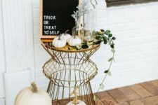 19 a boho chic outdoor display with a metlalic table, black candles, heirloom pumpkins, greenery and a sign