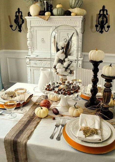 a cloche with nuts, a vintage urn with cotton and feathers plus pumpkins on the table for a vintage tablescape