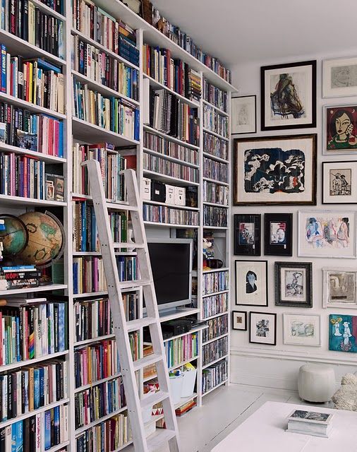 a large bookshelf unit that takes the whole wall is a great idea for a maximalist space, and artworks on the other wall help to show off the trend too