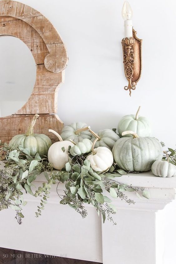 a neutral fall mantel with light green and white pumpkins plus seeded eucalyptus is great for Thanksgiving