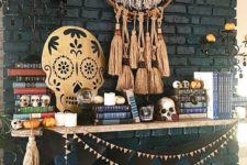 20 a cool mantel with a boho tassel dream catcher, a sugar skull artwork, a black bunting and some little skulls