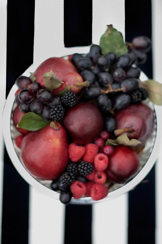 a jewel tone centerpiece of a silver bowl, burgundy pears, dark grapes and black berries to highlight the harvest time