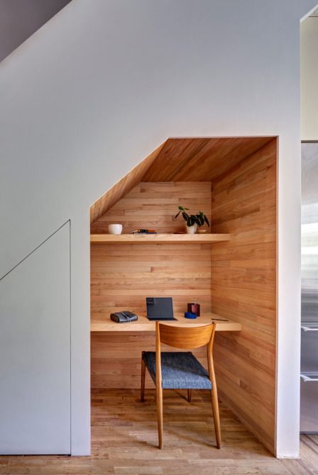 a small home office built in under the stairs and all clad with wood for a cozy feel