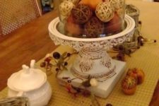 21 a fall vintage cloche display with fake fruits and twine balls for a rustic and vintage feel