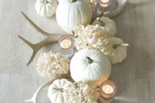 21 a neutral Thanksgiving centerpiece with white antlers, hydrangeas, pumpkins and candles will add a rustic touch to the space