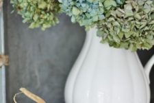 21 a vintage white pitcher with green hydrangeas and pumpkins around is a great decoration or a centerpiece