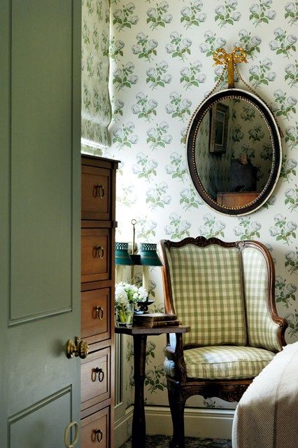 floral print wallpaper and a plaid upholstered chair look harmonious together and are perfect for a cottage