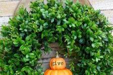 22 a cool and fresh Thanksgiving wreath of boxwood and little pumpkins and a large burlap bow for your front door