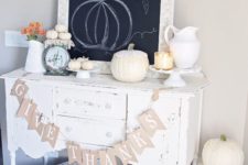 22 a neutral Thanksgiving console with a banner, heirloom pumpkins, little white ones and a jug