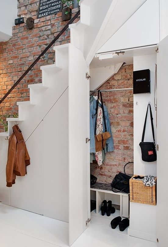 under the stairs space used as a mudroom with enough storage, shelves and holders