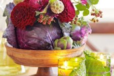 23 a Thanksgiving centerpiece with a wooden bowl, a purple cabbage, burgundy and fuchsia blooms